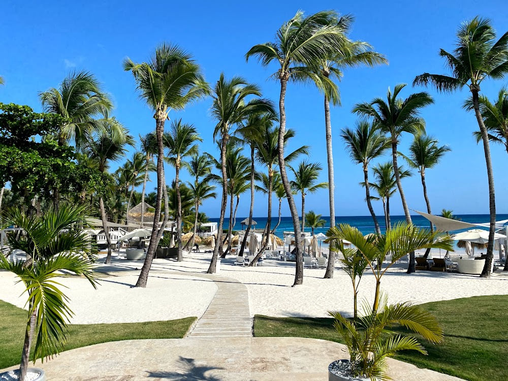 Caletón Beach Club in Cap Cana with palm trees, white sand, and cabanas